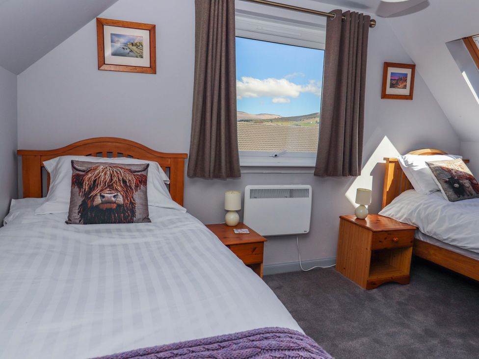 A bedroom with two beds and a window at Ceól na Mara, Uig
