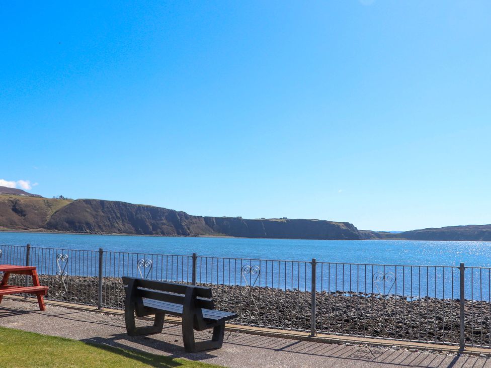 A view of the sea and cliffs with benches at Ceól na Mara in Uig