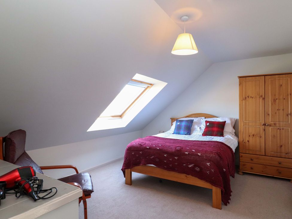 A bedroom with a bed and wardrobe at Ceól na Mara, Uig