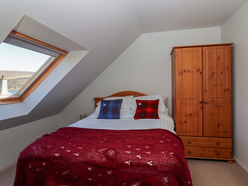 A bedroom with a bed and a wardrobe at Ceól na Mara in Uig