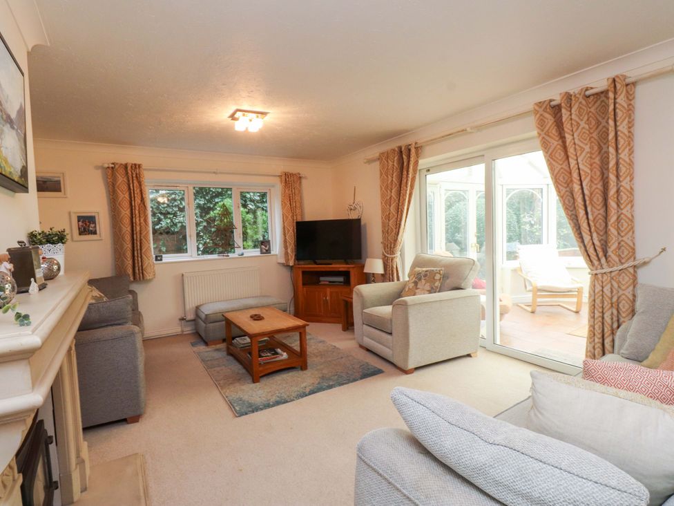 A living room with a sofa and television at Fernlea in Morfa Nefyn