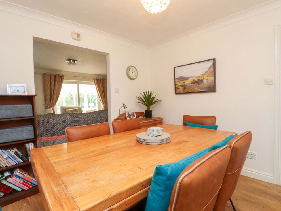 A dining room with a table and chairs at Fernlea in Morfa Nefyn