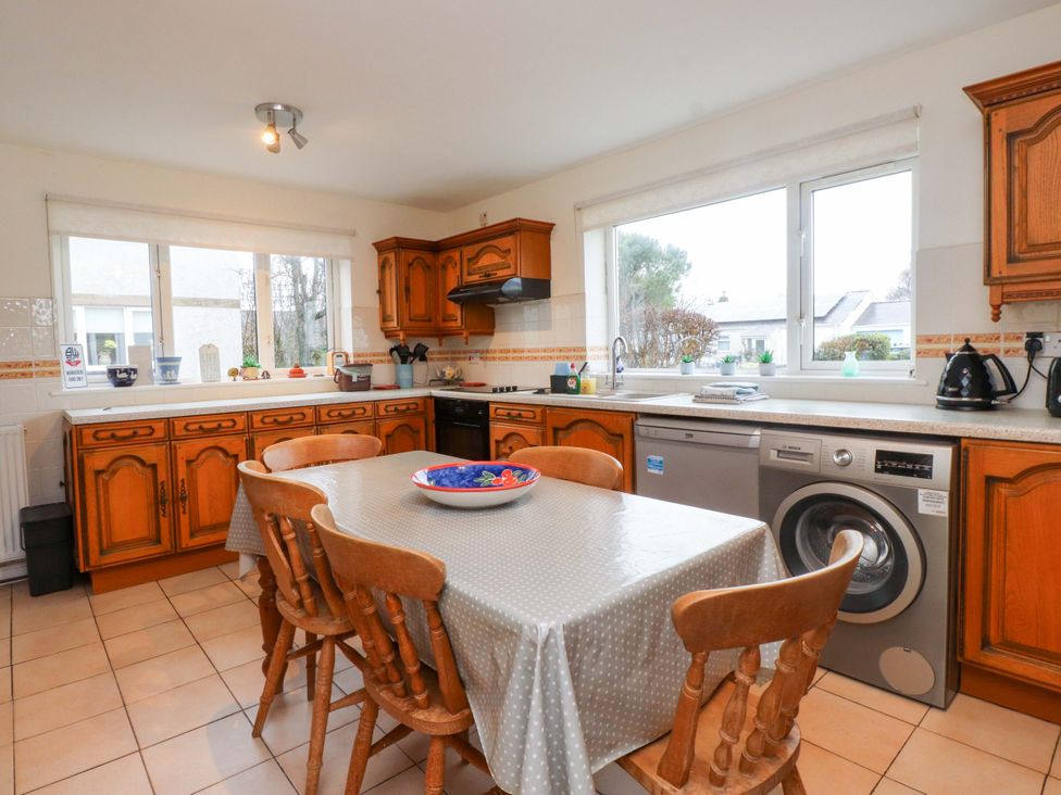 A kitchen with a table and chairs at Fernlea in Morfa Nefyn