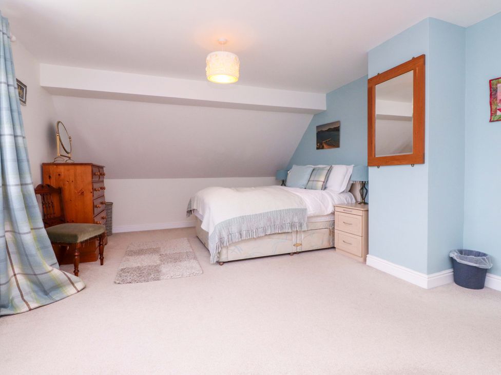 A bedroom with a bed and furniture at Fernlea in Morfa Nefyn