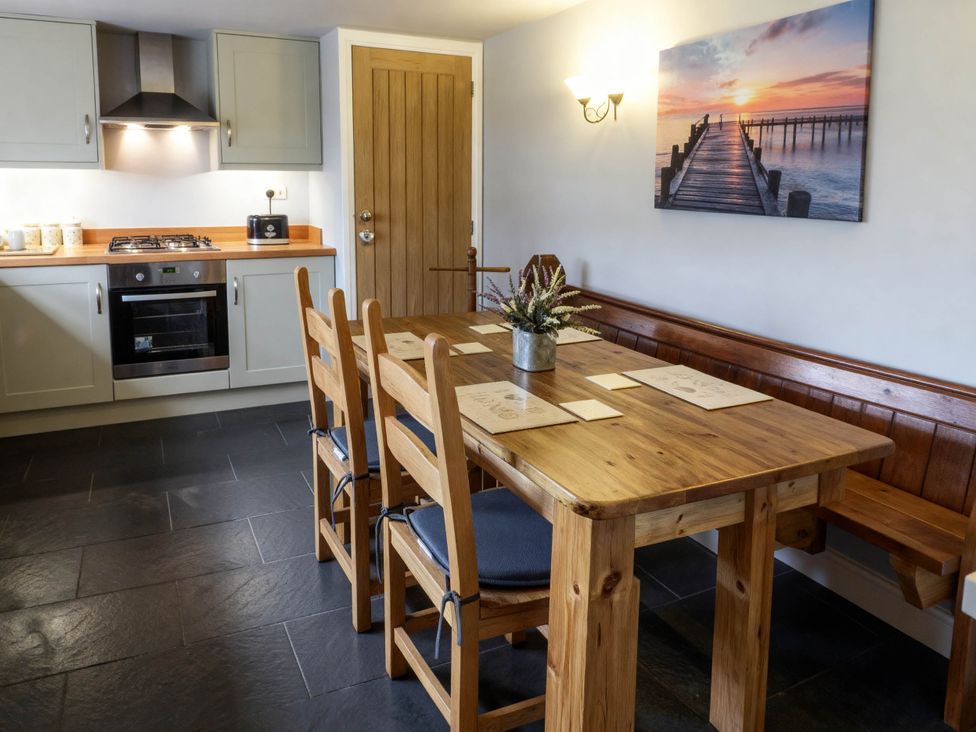 A dining room with a wooden table and chairs at Little Owl Barn in Longnor