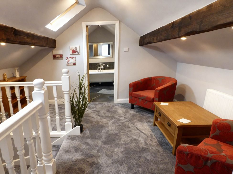 A landing with armchairs and a coffee table at Little Owl Barn in Longnor