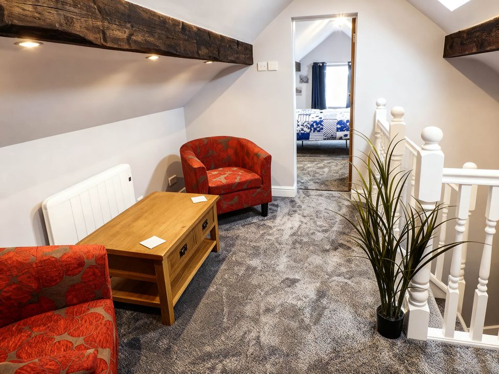 A landing with armchairs and a coffee table at Little Owl Barn in Longnor