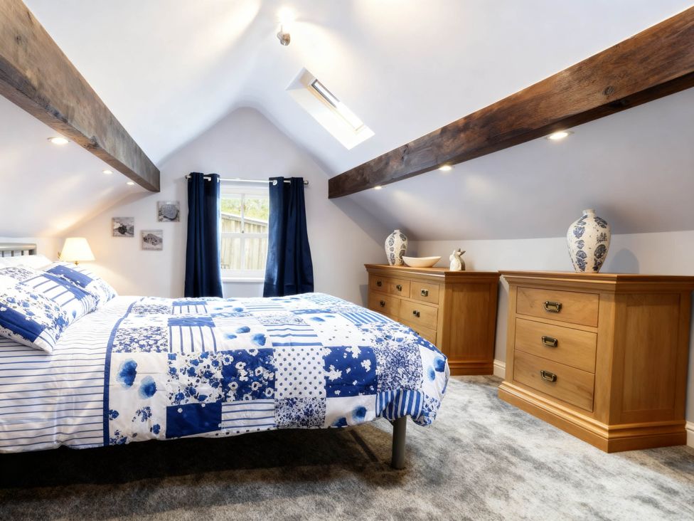 A bedroom with a bed and wooden furniture at Little Owl Barn Longnor