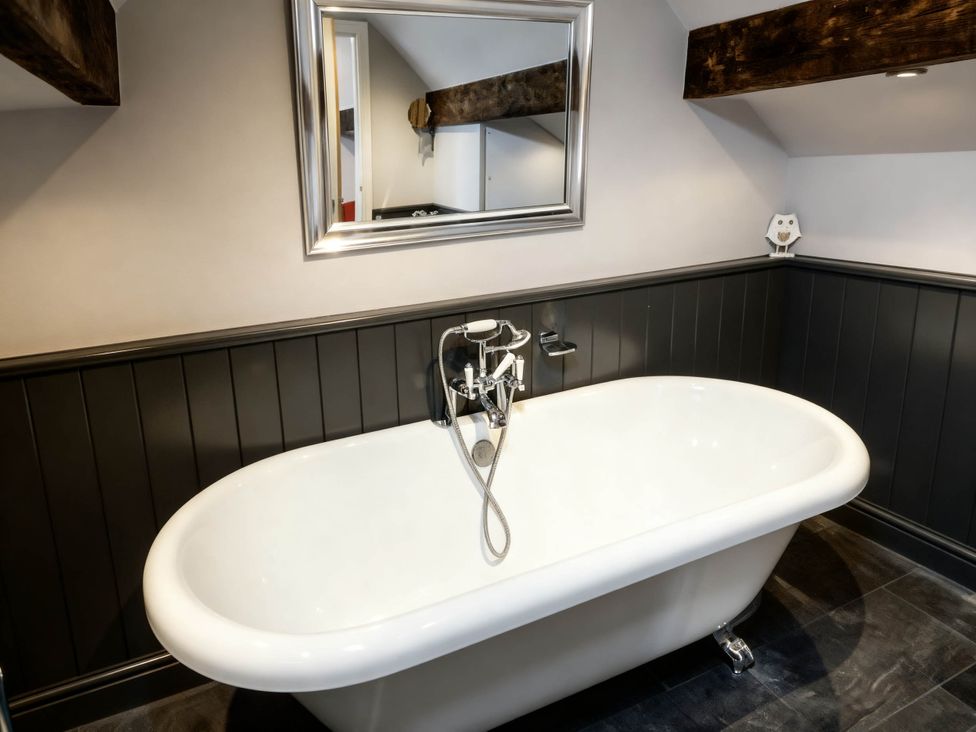A bathroom with a bathtub and a mirror at Little Owl Barn in Longnor