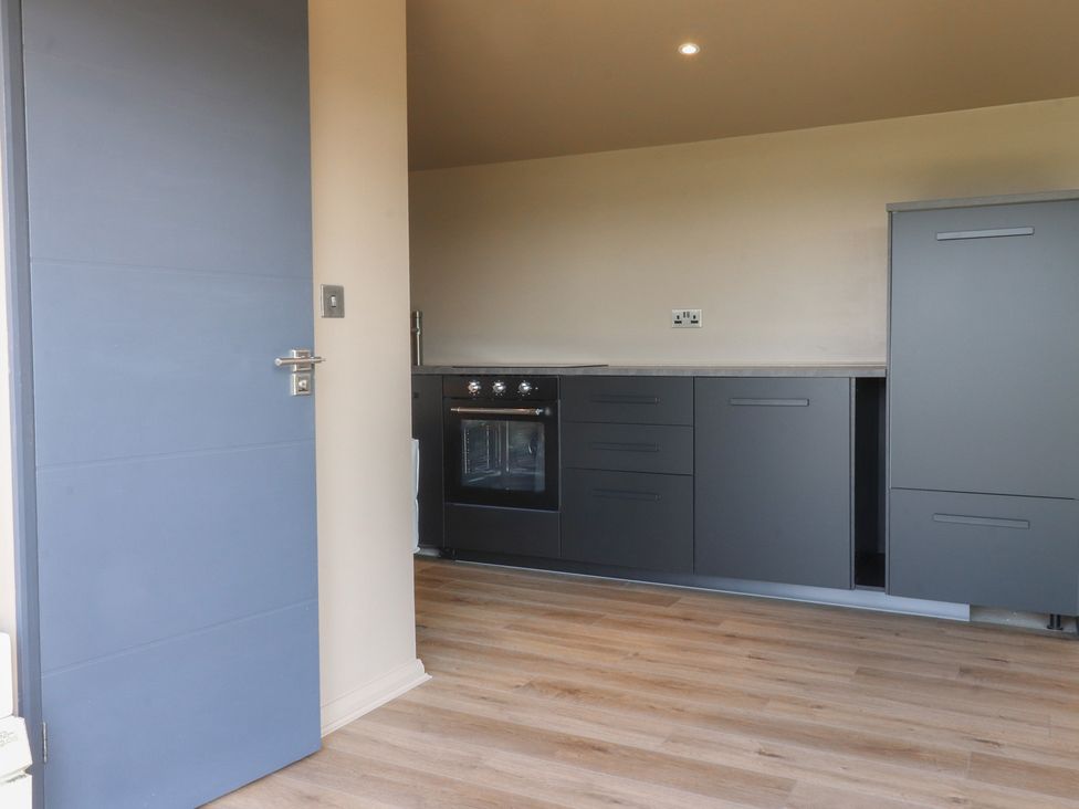 A kitchen with a door and modern cabinets at Heath Hideaway