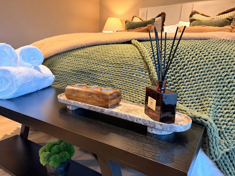 A bedroom with a bed, towels, and an aroma diffuser at Heath Hideaway Norland near Ripponden