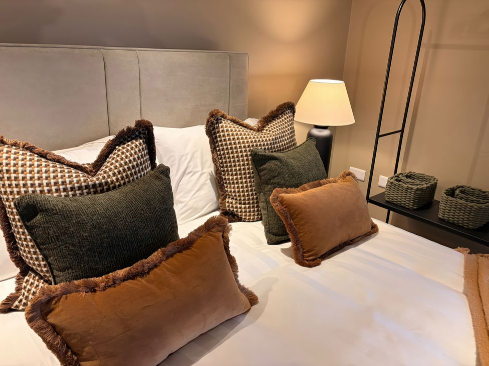 A bedroom with pillows on a bed and a lamp at Heath Hideaway near Ripponden