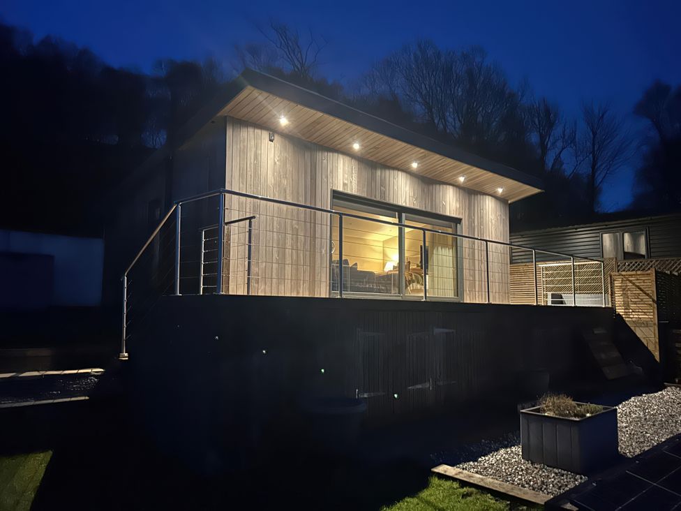 A wooden house with a deck and railing at Heath Hideaway Norland near Ripponden