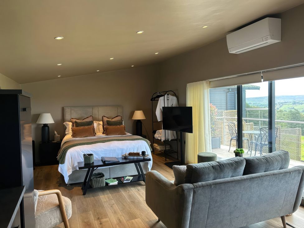 A bedroom with a bed and seating area at Heath Hideaway in Norland near Ripponden