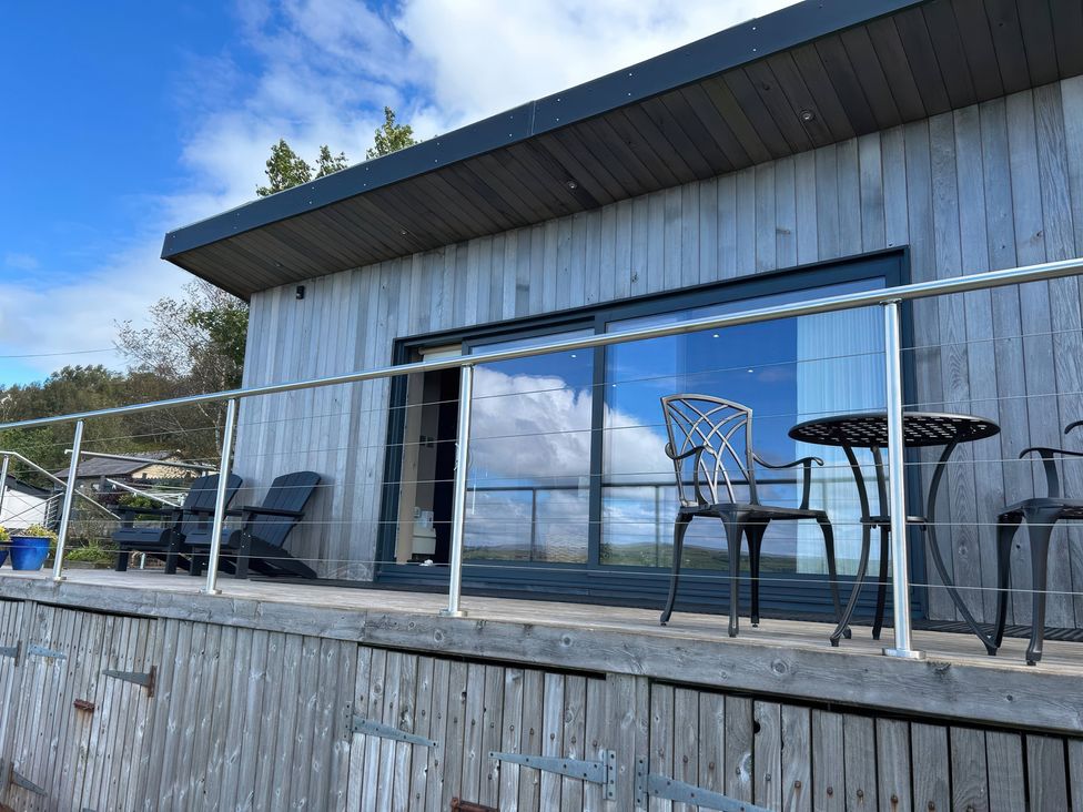 An outdoor terrace with chairs and a table at Heath Hideaway in Norland near Ripponden