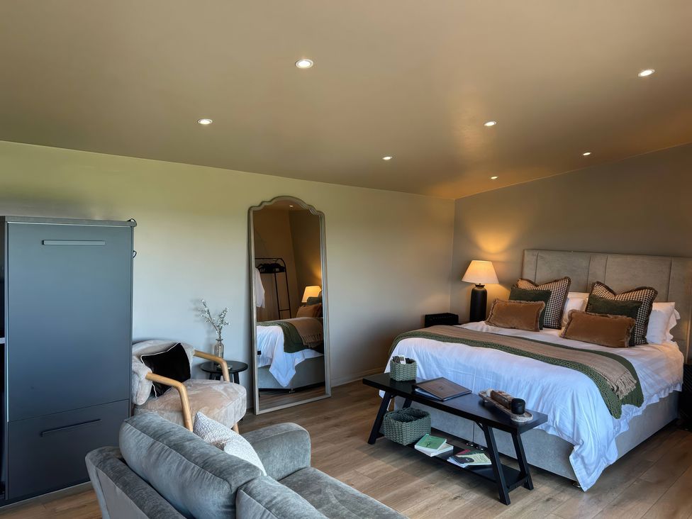 A bedroom with a bed and a mirror at Heath Hideaway in Norland near Ripponden