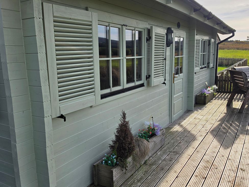 An exterior view of a cabin with planters at The Shooting Lodge in Longnor