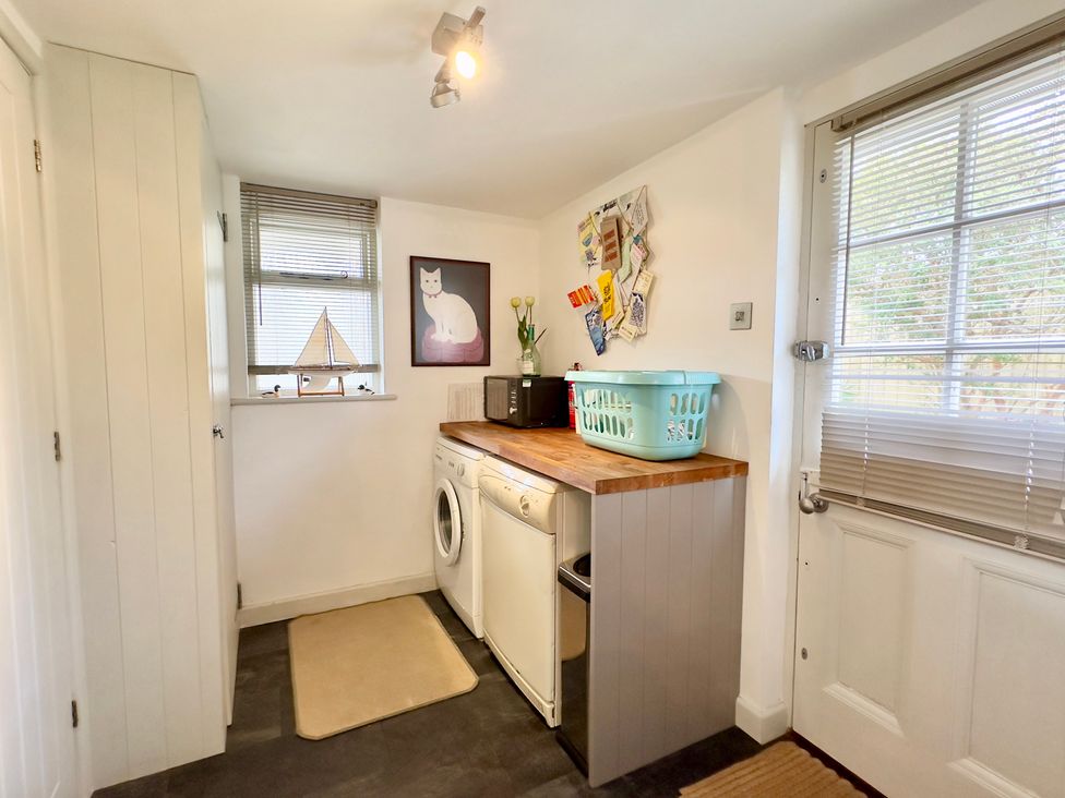 A utility room with washing machine and countertop at Kilcarreg Rock near Wadebridge