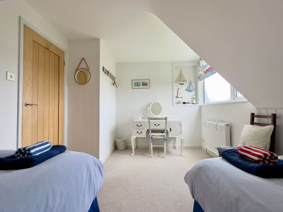 A bedroom with two beds and a desk at Kilcarreg in Rock near Wadebridge