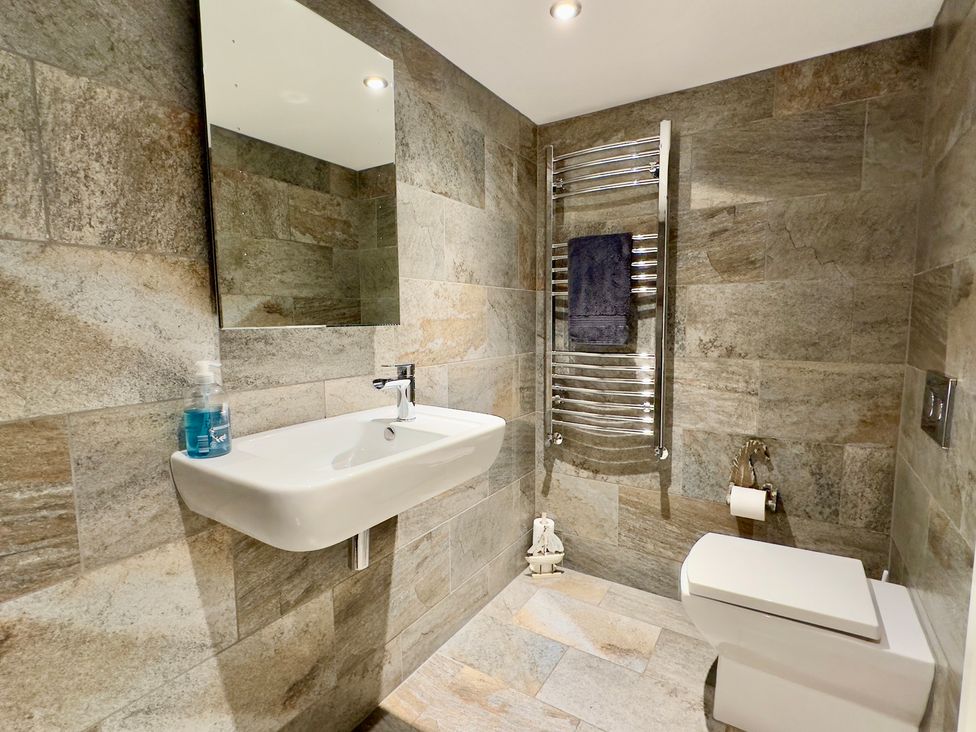 A bathroom with a sink, toilet, and towel rail at Kilcarreg in Rock near Wadebridge