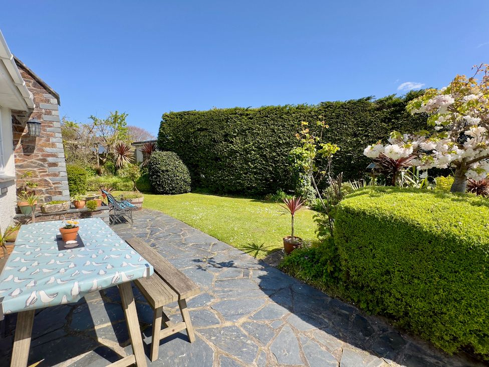 A garden with a table and plants at Kilcarreg in Rock near Wadebridge