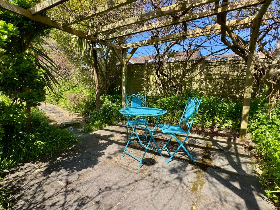 A garden with a blue table and chairs at Kilcarreg Rock near Wadebridge