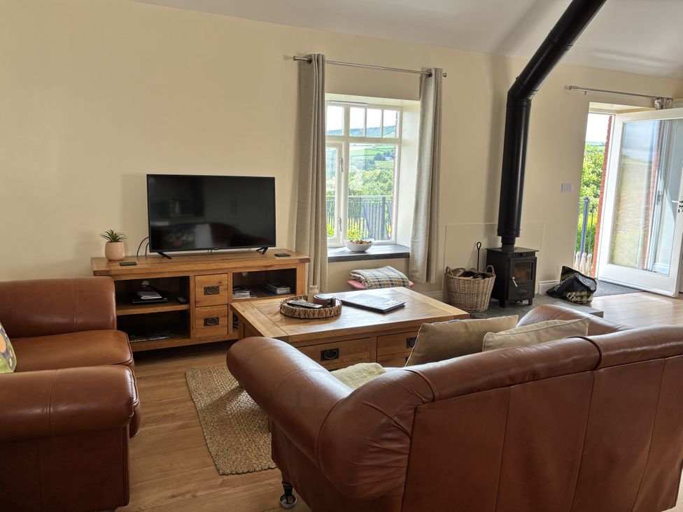 A living room with a television and coffee table at Llaethdy - The Dairy in Boncath near Crymych