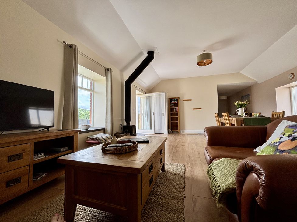 A living room with a television and coffee table at Llaethdy - The Dairy Boncath near Crymych