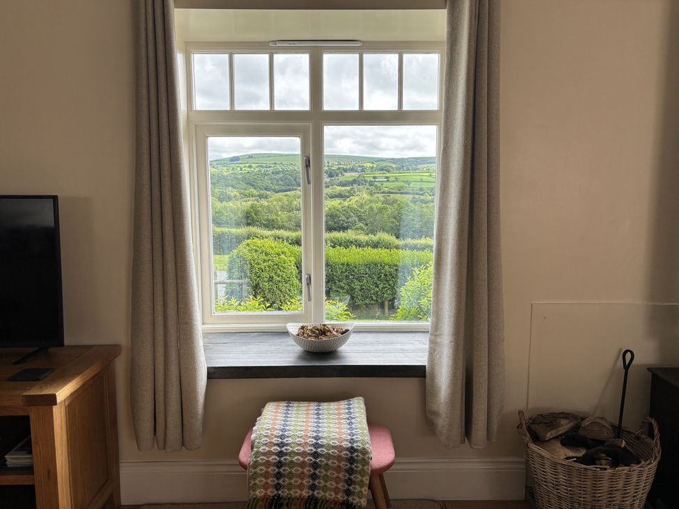 A living room with a window and a table at Llaethdy - The Dairy Boncath near Crymych