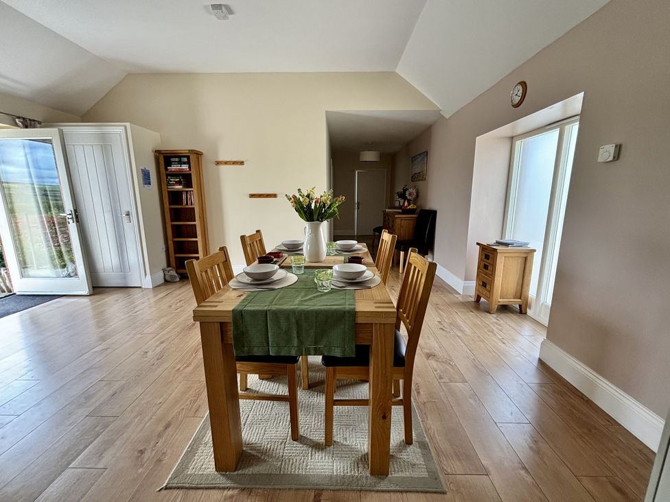 A dining room with a table set for meals at Llaethdy - The Dairy Boncath near Crymych
