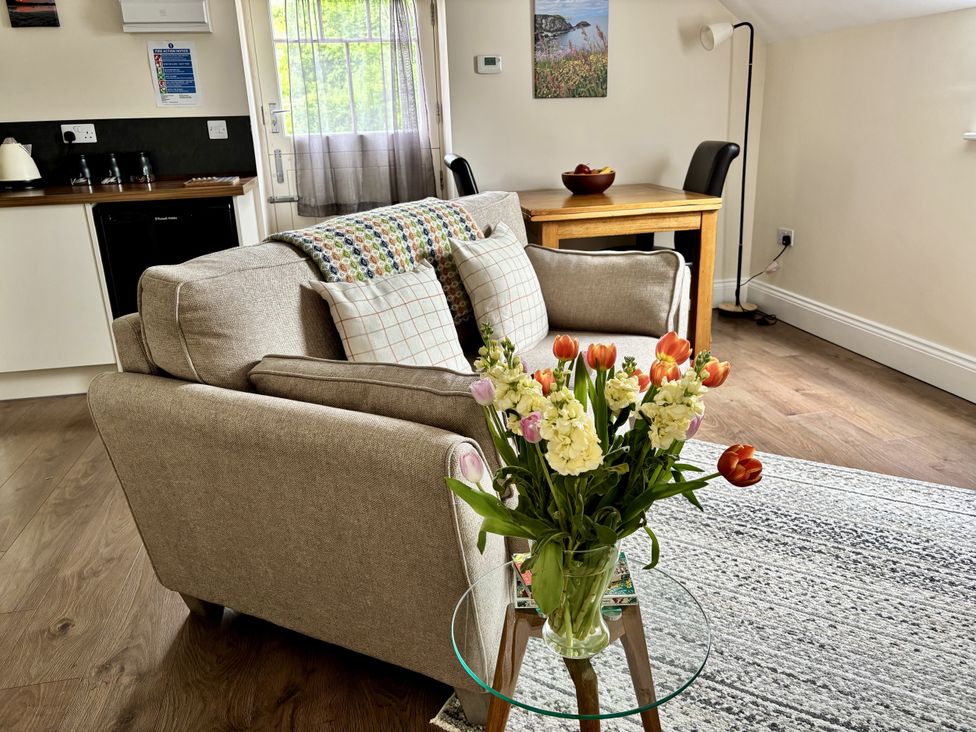 A living room with a sofa and table at Lloft Gwair - Hayloft Boncath near Crymych