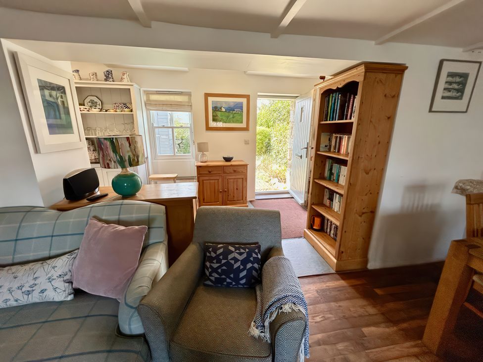 A living room with a sofa and bookshelf at 14 Boscaswell Downs in Pendeen near St Just