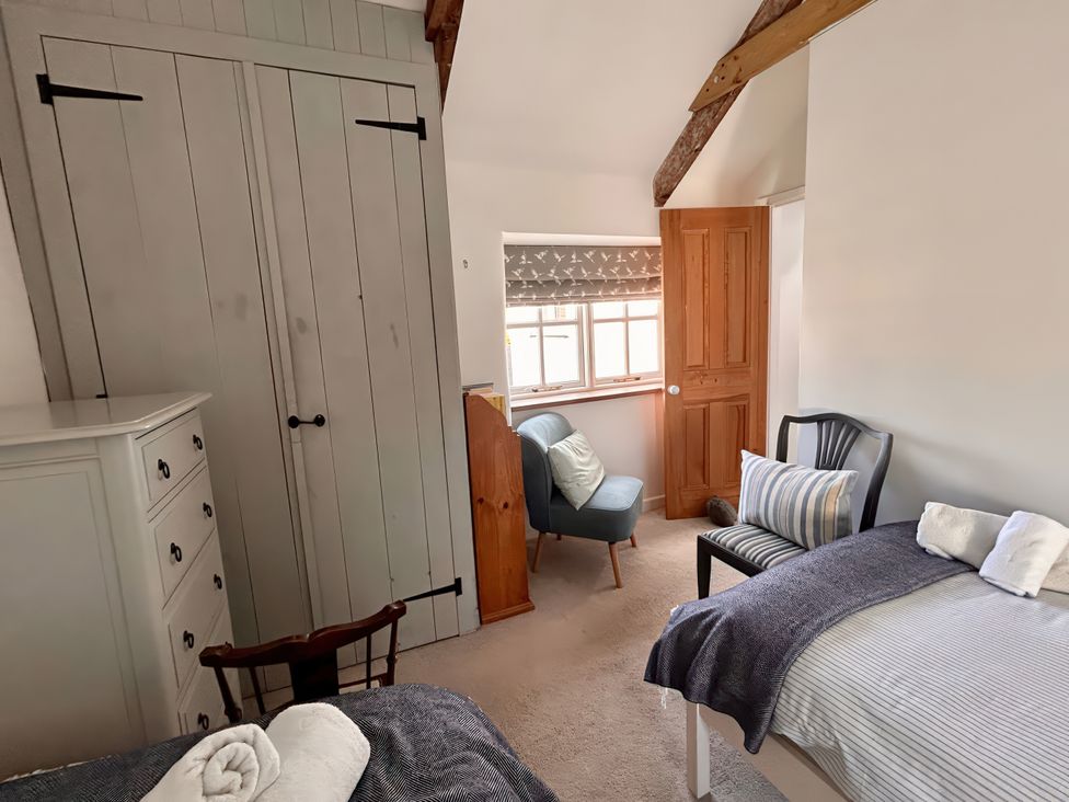 A bedroom with a wardrobe a dresser and a chair at 14 Boscaswell Downs Pendeen near St Just