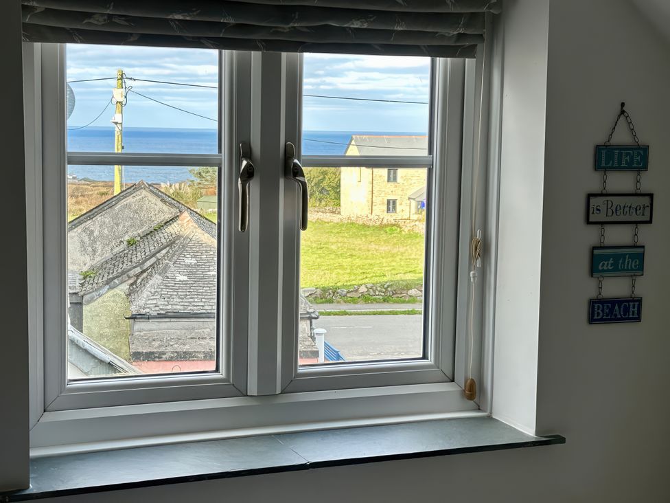A window with a view of the ocean and grass at 14 Boscaswell Downs Pendeen near St Just