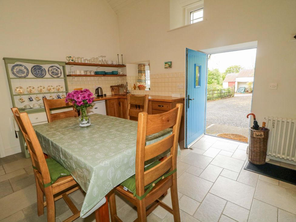 A kitchen with a table and chairs at Rosslare Cottage in Broughshane