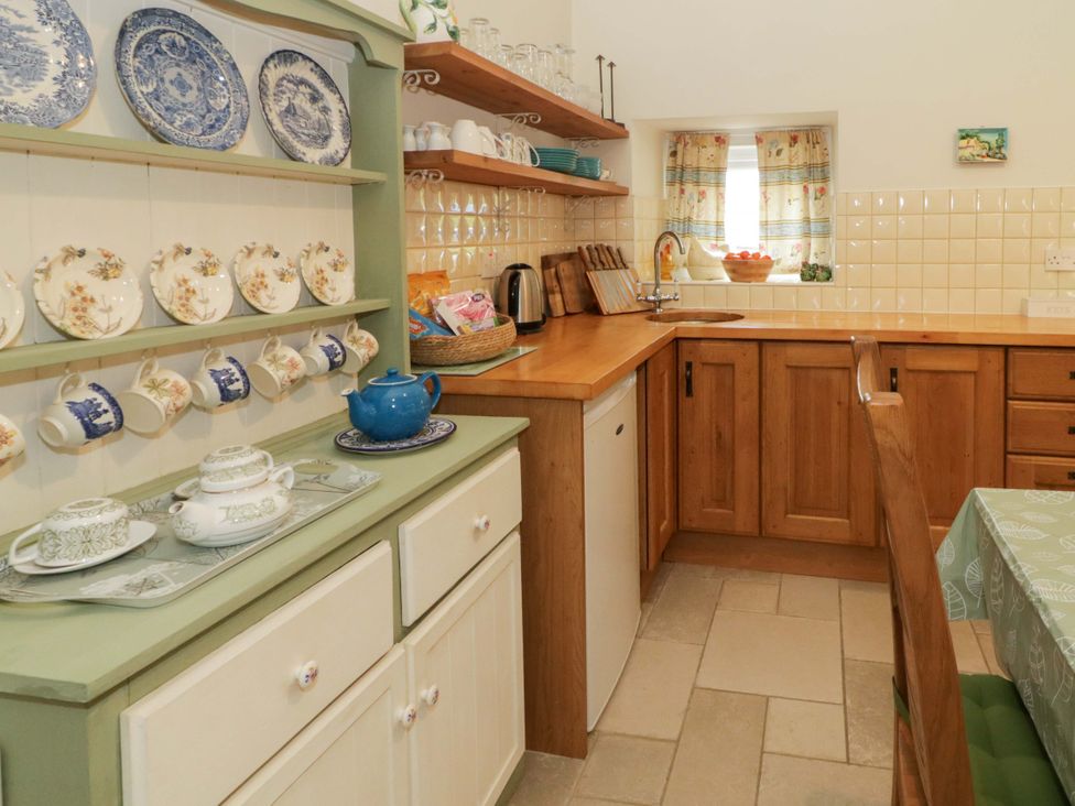 A kitchen with teapot and plates displayed at Rosslare Cottage Broughshane