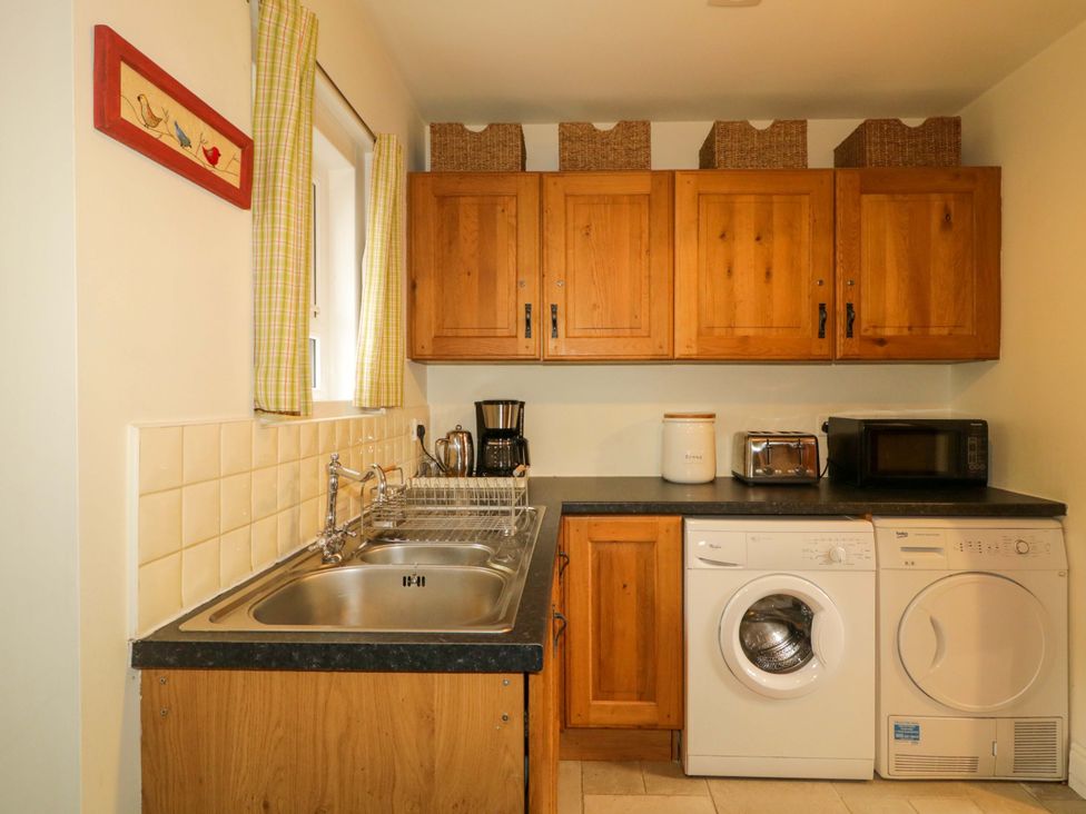 A kitchen with cabinets, sink, and appliances at Rosslare Cottage in Broughshane