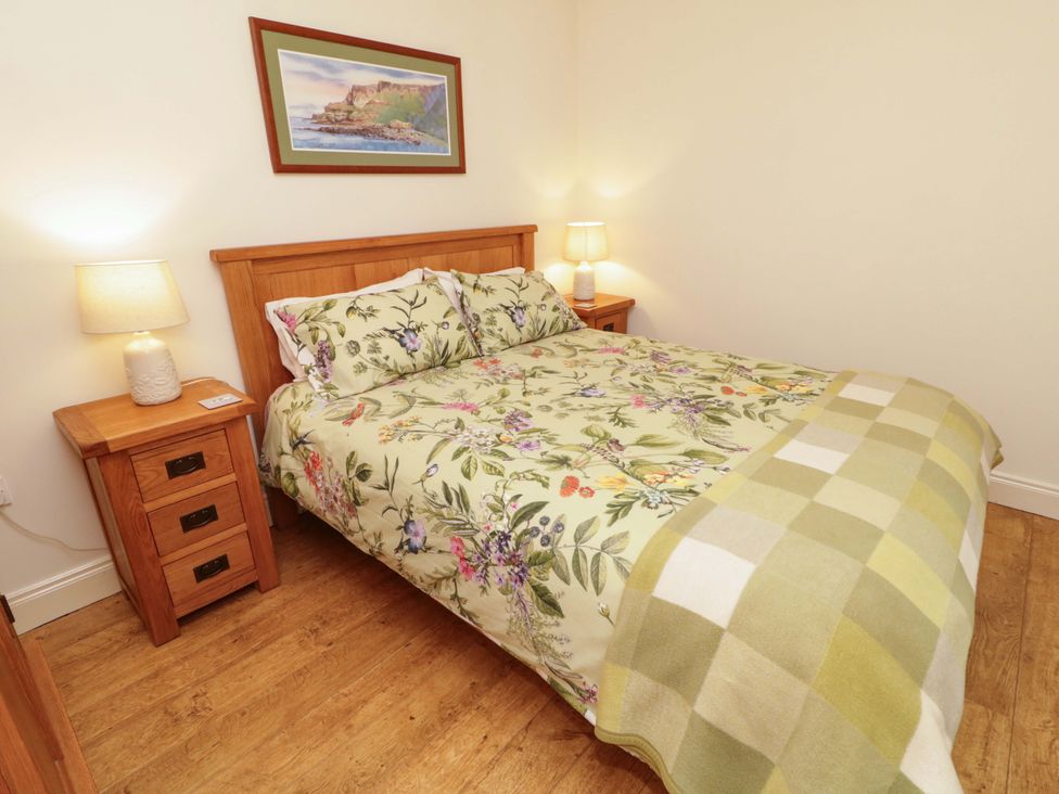A bedroom with a bed and nightstand at Rosslare Cottage Broughshane