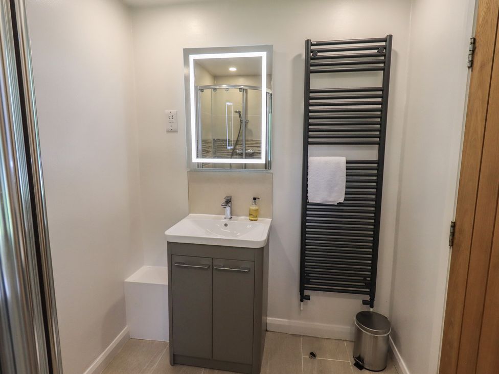 A bathroom with a sink and mirror at Yew - Woodland Cottages in Bowness-On-Windermere