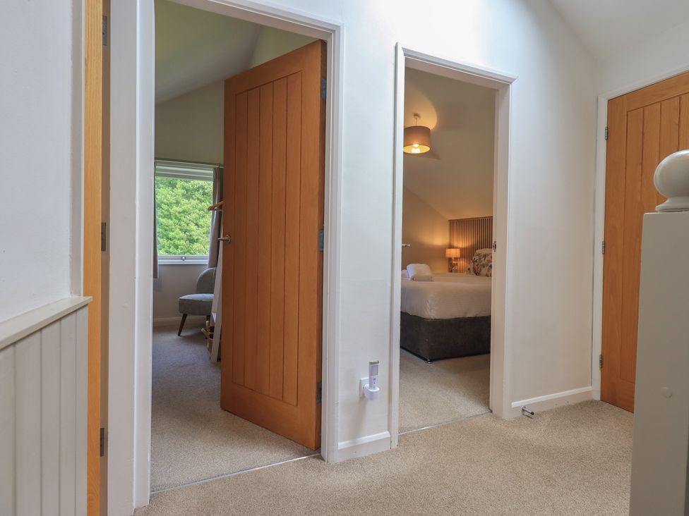 A hallway with doors leading to bedrooms at Yew - Woodland Cottages in Bowness-On-Windermere