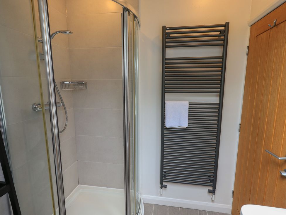 A bathroom featuring a shower and towel rail at Yew - Woodland Cottages in Bowness-On-Windermere