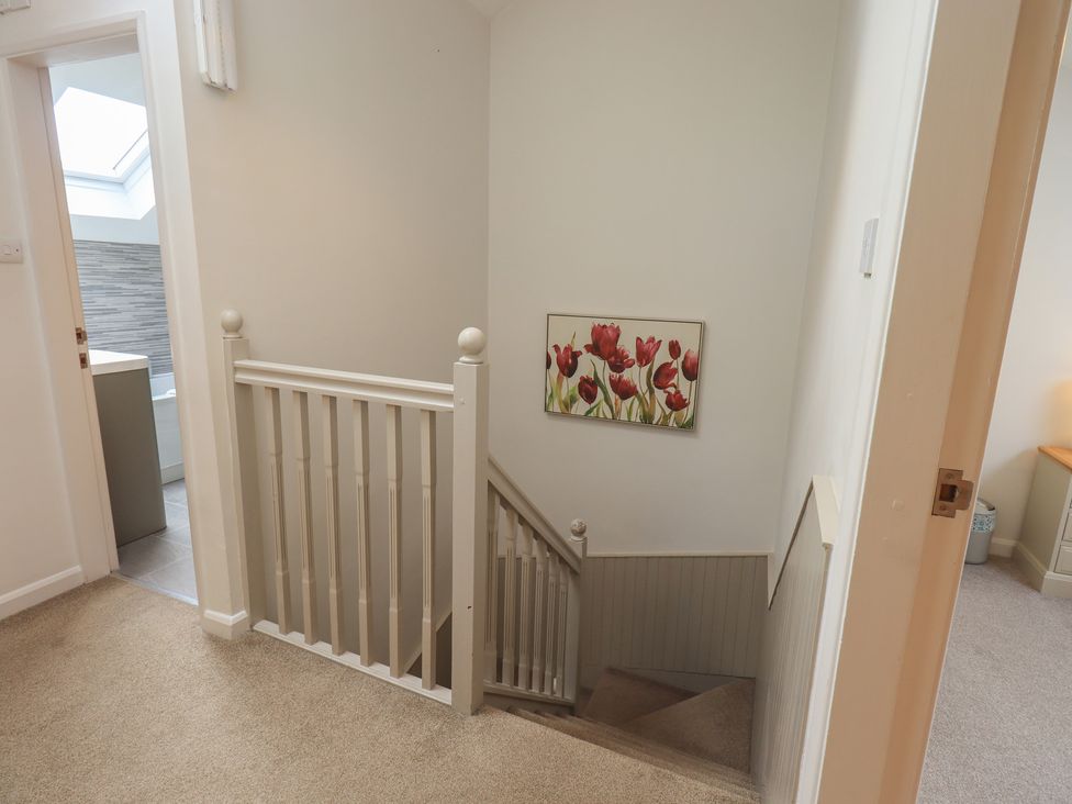 A staircase with wall art and a door at Yew - Woodland Cottages in Bowness-On-Windermere