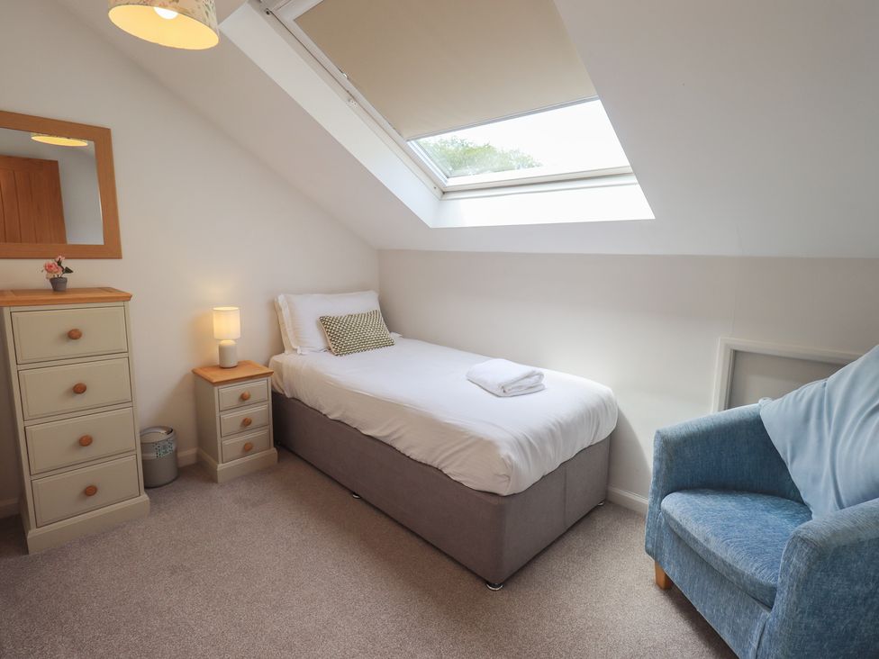 A bedroom with a single bed and bedside table at Yew - Woodland Cottages Bowness-On-Windermere