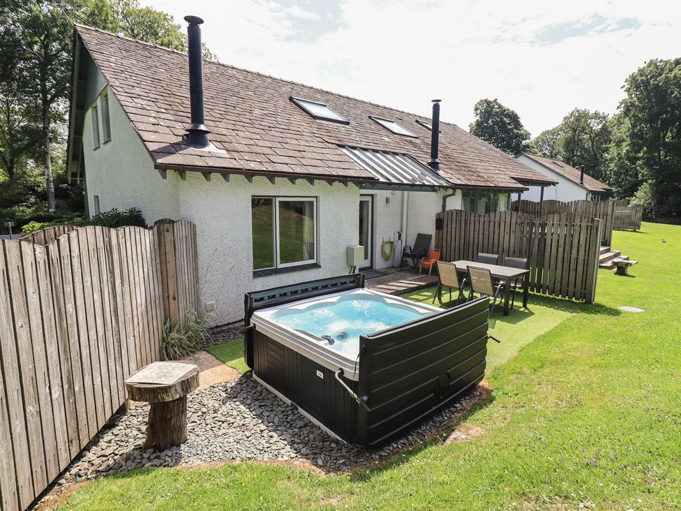 An outdoor area with a hot tub and seating at Yew - Woodland Cottages Bowness-On-Windermere