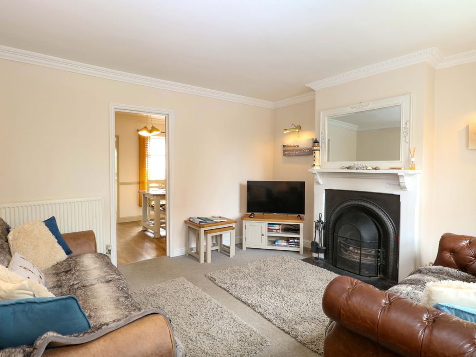 A living room with sofas and a television at Fern Cottage in Heacham