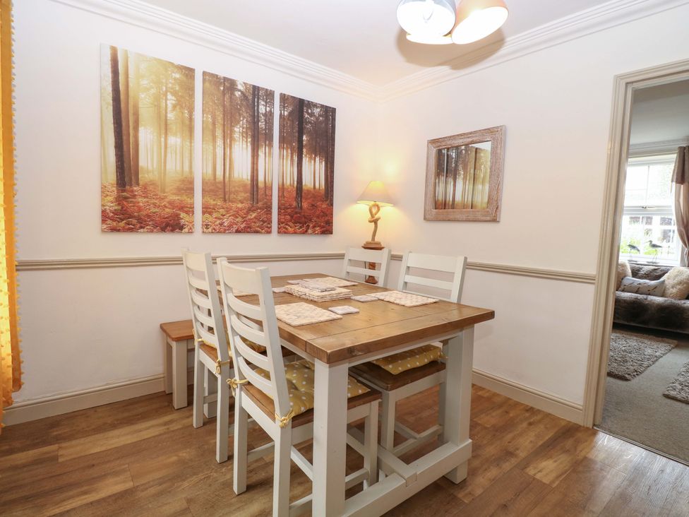 A dining room with a table and chairs at Fern Cottage Heacham