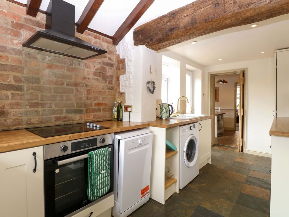 A kitchen with appliances and wooden surfaces at Fern Cottage Heacham