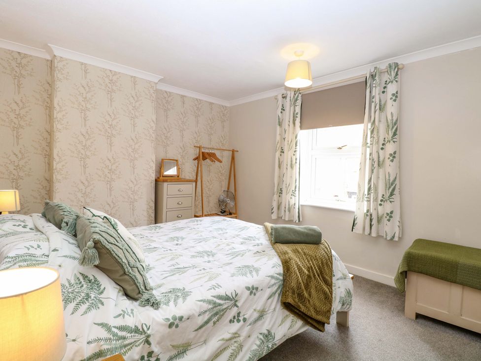 A bedroom with a bed and bedside table at Fern Cottage Heacham