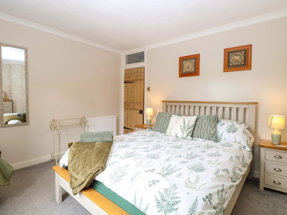 A bedroom with a bed and bedside tables at Fern Cottage Heacham