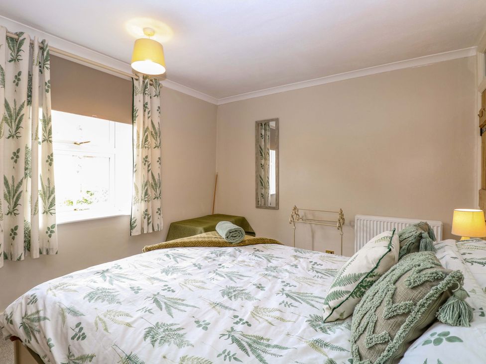 A bedroom with a bed and window at Fern Cottage in Heacham